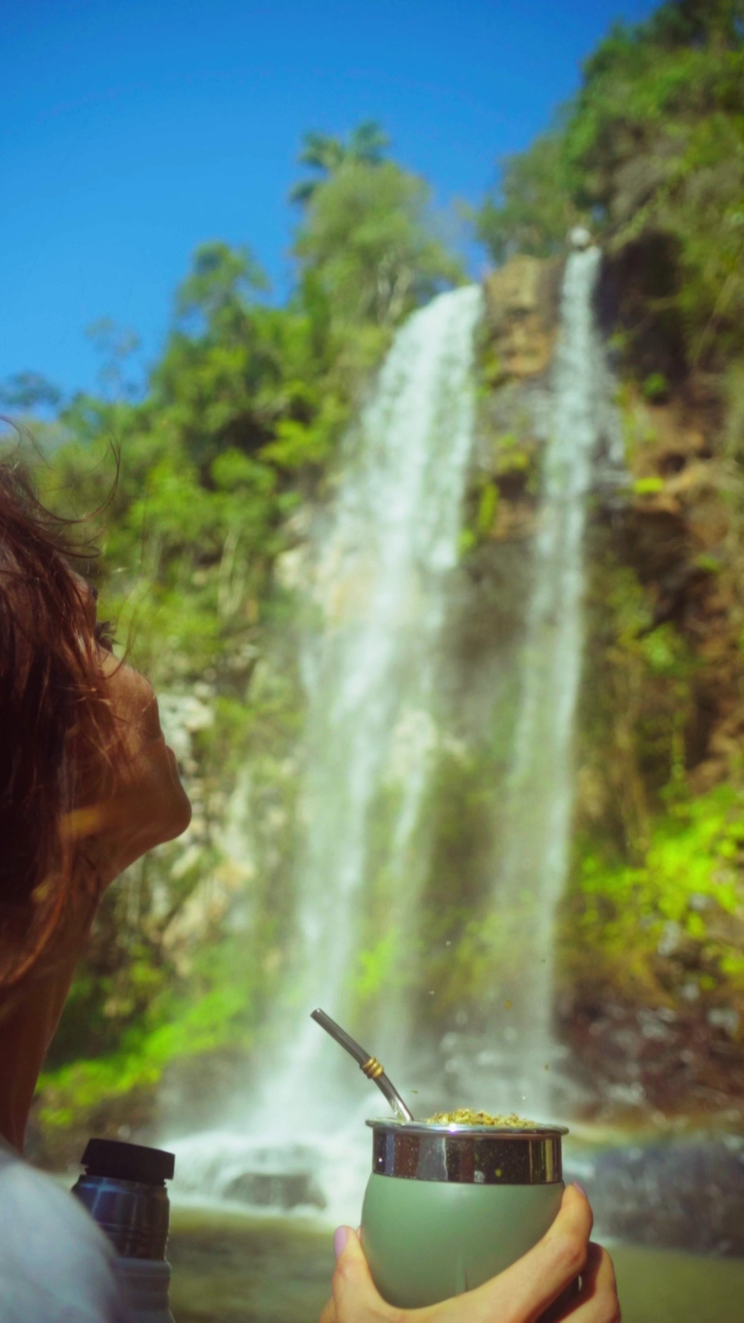 Mujer mirando catarata con Mate Pampa